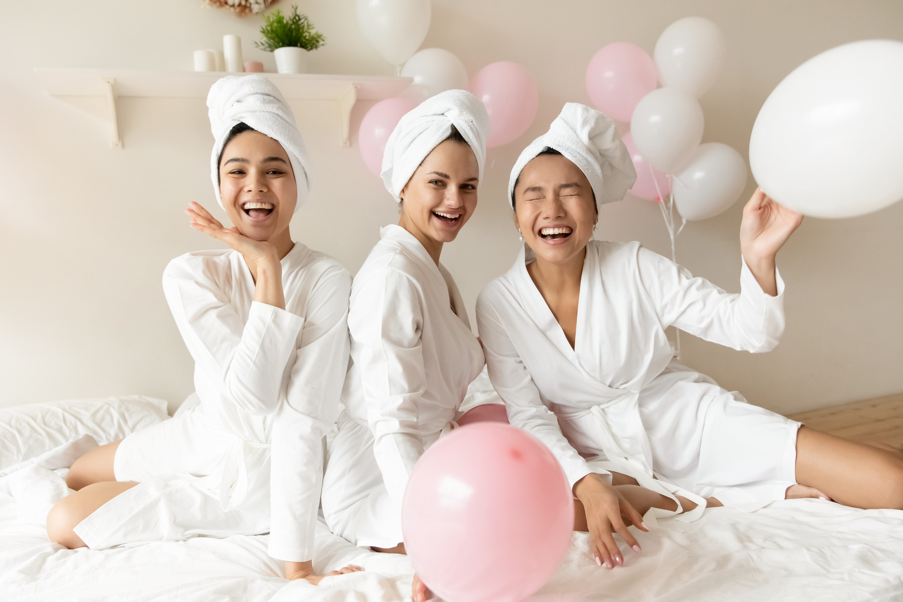 Well-groomed girls in bathrobes gather together celebrating bridal shower
