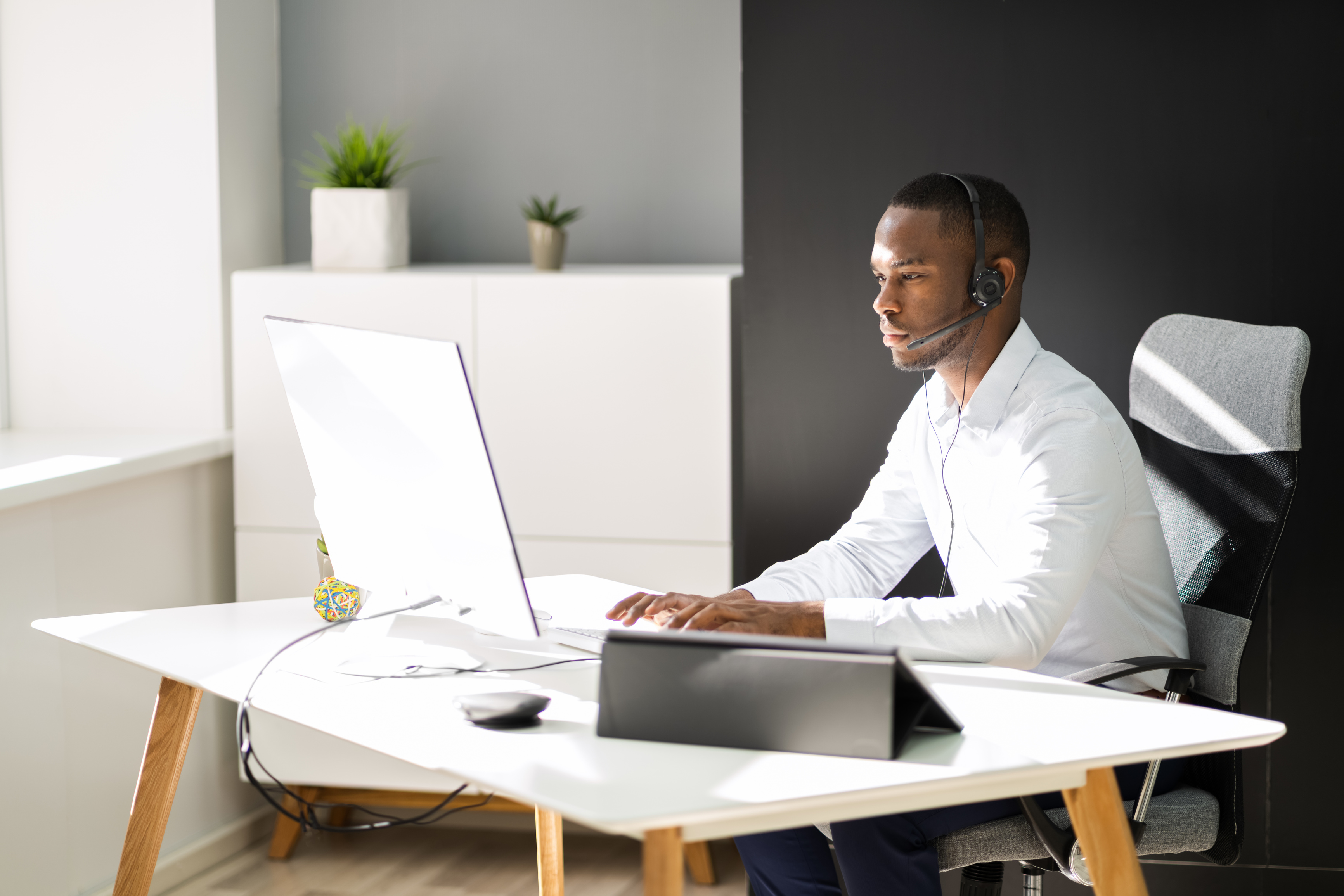 Business Service Agent With Headset At Computer